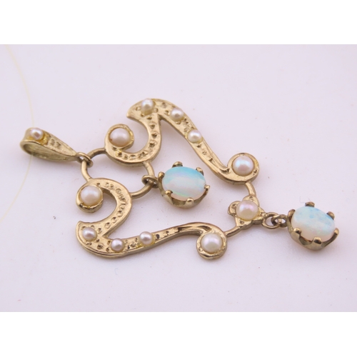 312 - A 9ct gold pendant of openwork heart form, set with opals and seed pearls. The stones displaying cha... 