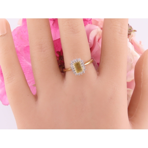 125 - An 18ct yellow gold ring claw set with a rectangular cut citrine accented by small brilliant cut dia... 