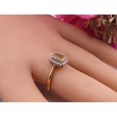 125 - An 18ct yellow gold ring claw set with a rectangular cut citrine accented by small brilliant cut dia... 