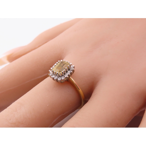 125 - An 18ct yellow gold ring claw set with a rectangular cut citrine accented by small brilliant cut dia... 