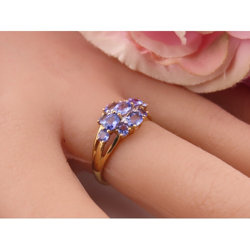 128 - A 9ct yellow gold ring set with an oval cut tanzanite in a claw mount with tapered shoulders. Ring s... 
