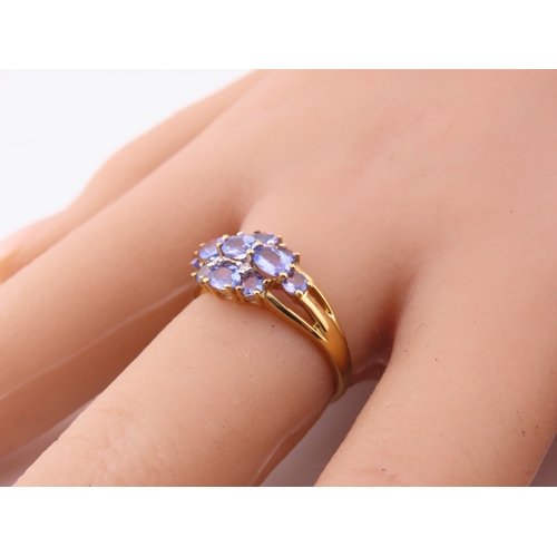 128 - A 9ct yellow gold ring set with an oval cut tanzanite in a claw mount with tapered shoulders. Ring s... 
