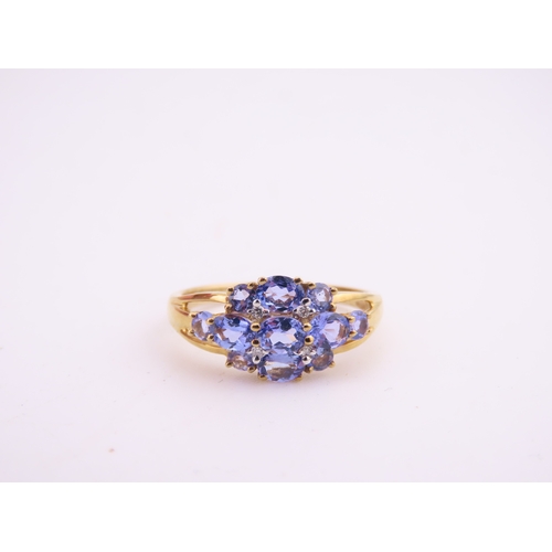 128 - A 9ct yellow gold ring set with an oval cut tanzanite in a claw mount with tapered shoulders. Ring s... 