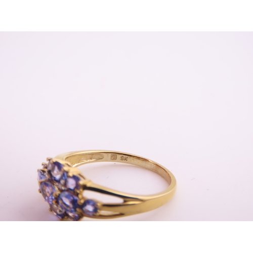 128 - A 9ct yellow gold ring set with an oval cut tanzanite in a claw mount with tapered shoulders. Ring s... 