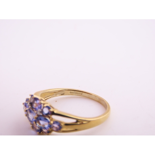 128 - A 9ct yellow gold ring set with an oval cut tanzanite in a claw mount with tapered shoulders. Ring s... 