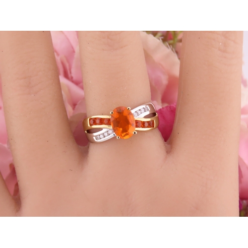 129 - A 9ct yellow and white gold ring set with an oval fire opal accented by small brilliant cut diamonds... 