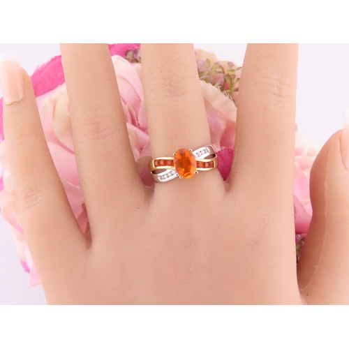 129 - A 9ct yellow and white gold ring set with an oval fire opal accented by small brilliant cut diamonds... 