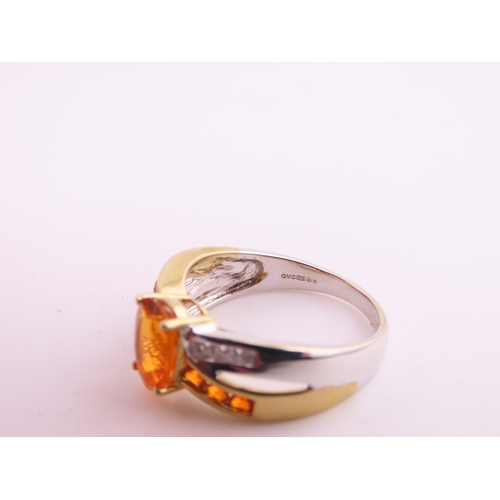 129 - A 9ct yellow and white gold ring set with an oval fire opal accented by small brilliant cut diamonds... 
