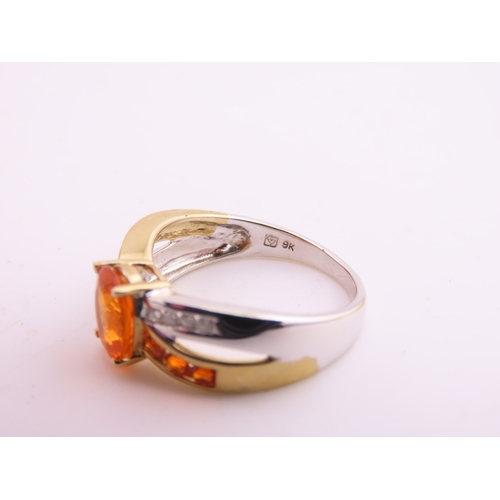 129 - A 9ct yellow and white gold ring set with an oval fire opal accented by small brilliant cut diamonds... 