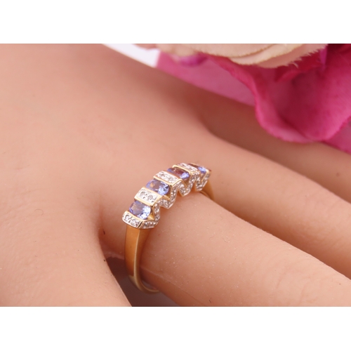 130 - A 14ct yellow gold ring set with rectangular cut tanzanites interspersed with small diamonds in a ch... 