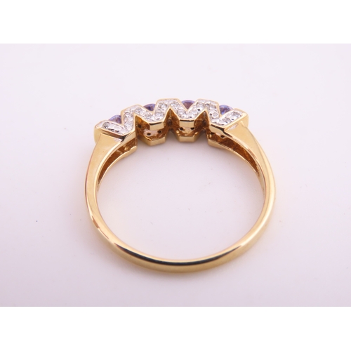 130 - A 14ct yellow gold ring set with rectangular cut tanzanites interspersed with small diamonds in a ch... 