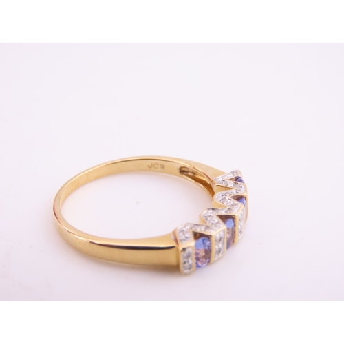 130 - A 14ct yellow gold ring set with rectangular cut tanzanites interspersed with small diamonds in a ch... 