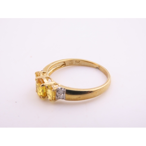 144 - A 9ct gold ring set with a citrine accented by small diamonds. Ring size M. Gross weight 1.9 grams.