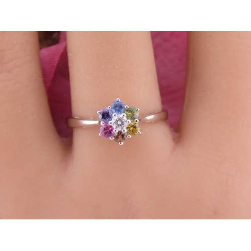 146 - An 18ct white gold floral cluster ring set with multiple gemstones forming a flower head. Ring size ... 