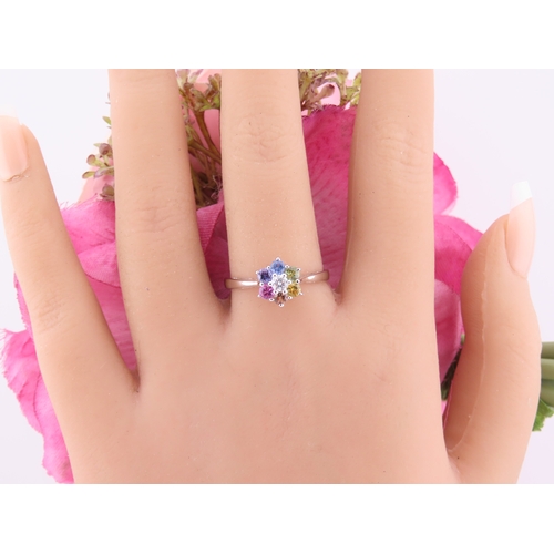 146 - An 18ct white gold floral cluster ring set with multiple gemstones forming a flower head. Ring size ... 