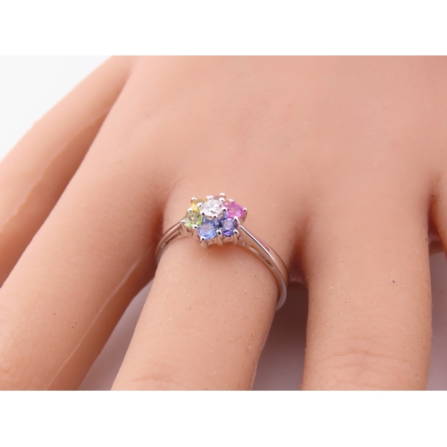 146 - An 18ct white gold floral cluster ring set with multiple gemstones forming a flower head. Ring size ... 