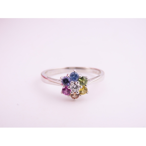 146 - An 18ct white gold floral cluster ring set with multiple gemstones forming a flower head. Ring size ... 