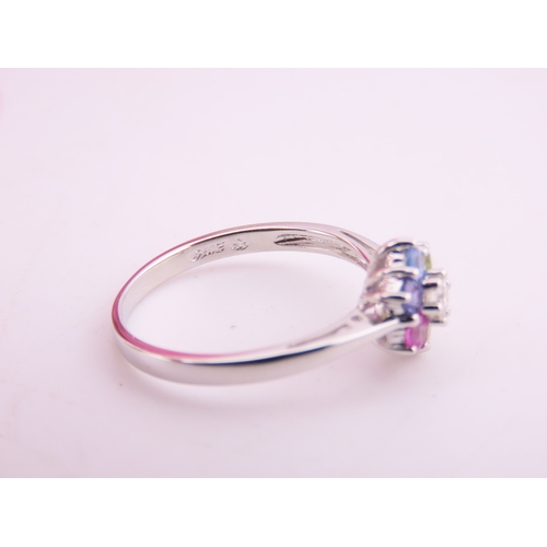 146 - An 18ct white gold floral cluster ring set with multiple gemstones forming a flower head. Ring size ... 