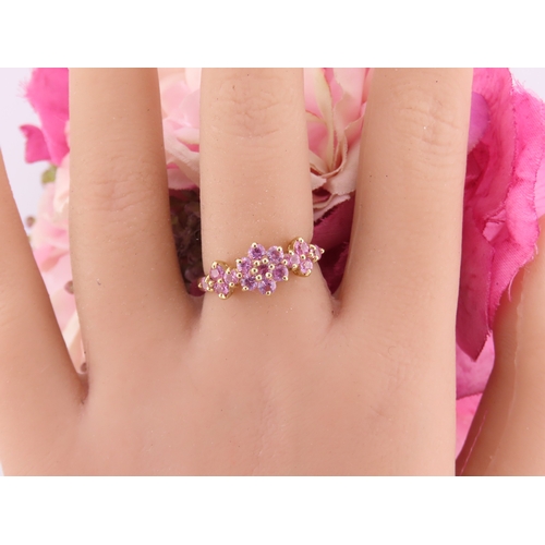 147 - A 9ct gold ring set with multiple pink sapphires in a decorative cluster. Ring size M. Gross weight ... 