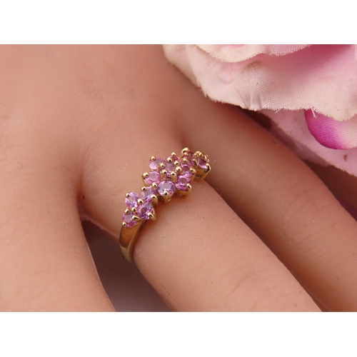 147 - A 9ct gold ring set with multiple pink sapphires in a decorative cluster. Ring size M. Gross weight ... 