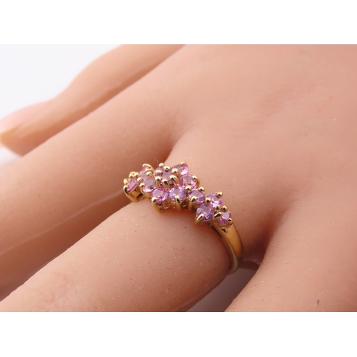 147 - A 9ct gold ring set with multiple pink sapphires in a decorative cluster. Ring size M. Gross weight ... 