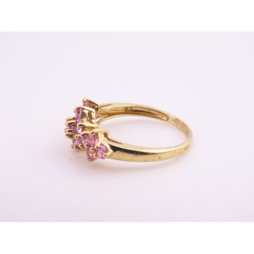 147 - A 9ct gold ring set with multiple pink sapphires in a decorative cluster. Ring size M. Gross weight ... 