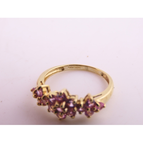 147 - A 9ct gold ring set with multiple pink sapphires in a decorative cluster. Ring size M. Gross weight ... 