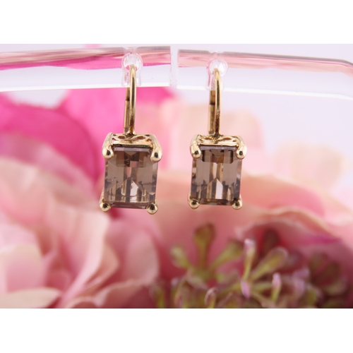 175 - Pair of 9ct Gold Smoky Quartz Earrings. Each set with an oval cut smoky quartz within a plain gold s... 