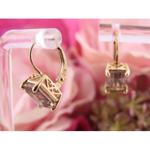 175 - Pair of 9ct Gold Smoky Quartz Earrings. Each set with an oval cut smoky quartz within a plain gold s... 