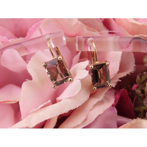 175 - Pair of 9ct Gold Smoky Quartz Earrings. Each set with an oval cut smoky quartz within a plain gold s... 