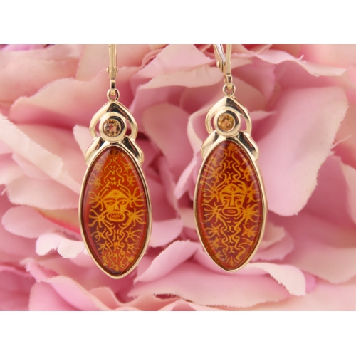 182 - Pair of 9ct Gold Amber Earrings. Each set with carved oval amber panels depicting decorative motifs ... 