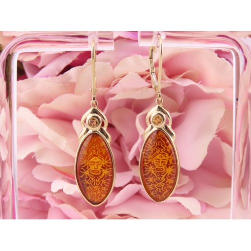 182 - Pair of 9ct Gold Amber Earrings. Each set with carved oval amber panels depicting decorative motifs ... 