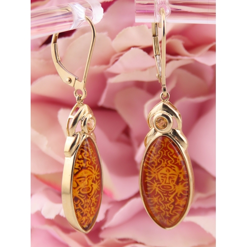 182 - Pair of 9ct Gold Amber Earrings. Each set with carved oval amber panels depicting decorative motifs ... 
