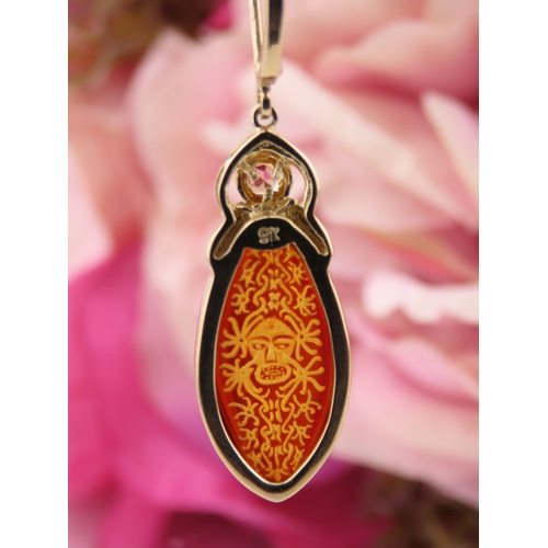 182 - Pair of 9ct Gold Amber Earrings. Each set with carved oval amber panels depicting decorative motifs ... 