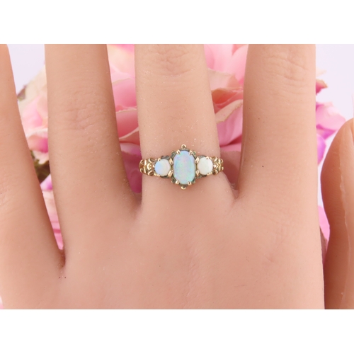 190 - A 9 carat gold opal trilogy ring, set with three graduated oval cabochon opals displaying characteri... 