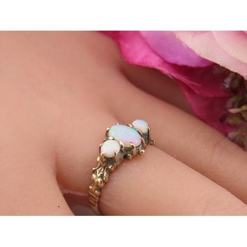 190 - A 9 carat gold opal trilogy ring, set with three graduated oval cabochon opals displaying characteri... 