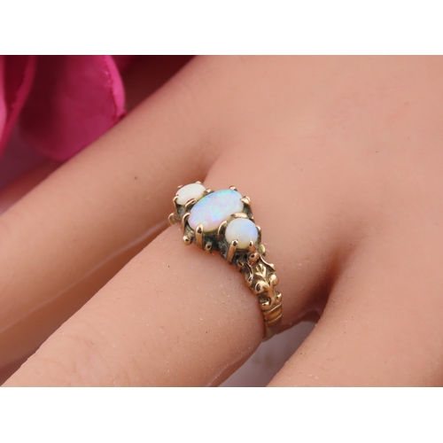 190 - A 9 carat gold opal trilogy ring, set with three graduated oval cabochon opals displaying characteri... 