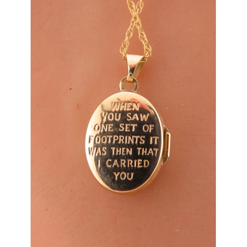 192 - A 9 carat gold oval locket, the front decorated with a raised footsteps motif, opening to reveal a g... 