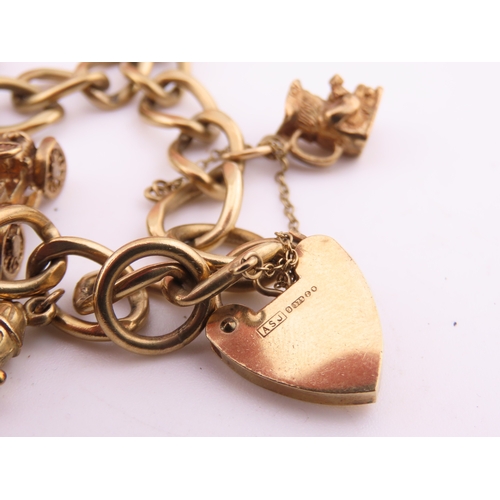 195 - A 9 carat gold charm bracelet, composed of a curb link chain fitted with a padlock clasp and suspend... 