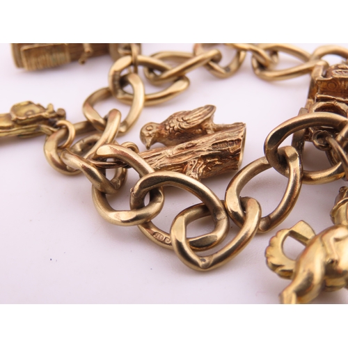 195 - A 9 carat gold charm bracelet, composed of a curb link chain fitted with a padlock clasp and suspend... 