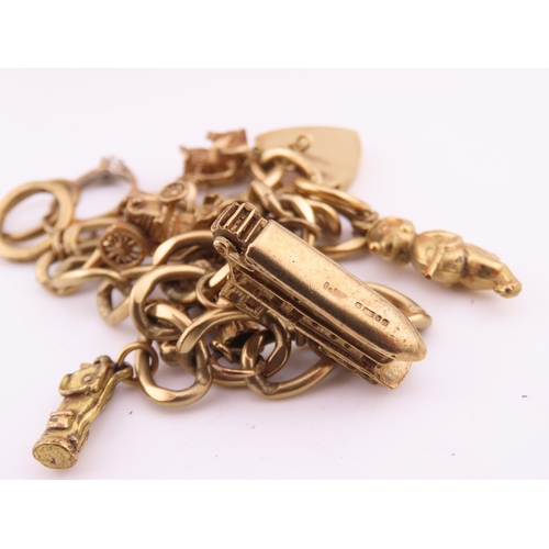 195 - A 9 carat gold charm bracelet, composed of a curb link chain fitted with a padlock clasp and suspend... 