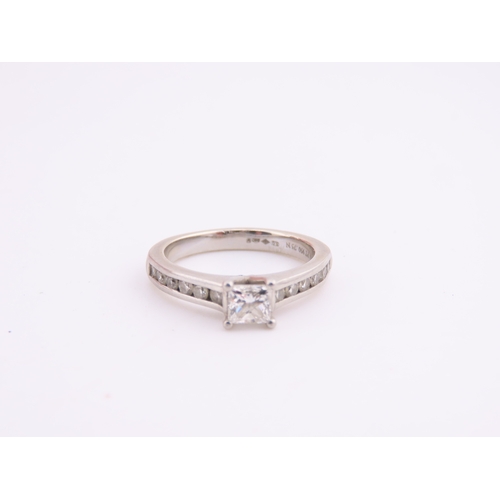 196 - A platinum diamond ring, set with a square cut central diamond flanked by graduated diamonds to each... 