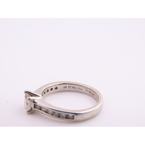 196 - A platinum diamond ring, set with a square cut central diamond flanked by graduated diamonds to each... 