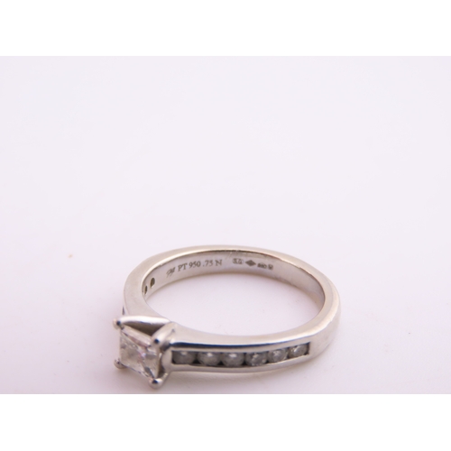 196 - A platinum diamond ring, set with a square cut central diamond flanked by graduated diamonds to each... 