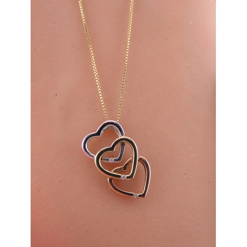 197 - A Brooks Bentley 9 carat tri colour gold heart pendant, formed as an interlocking three heart design... 