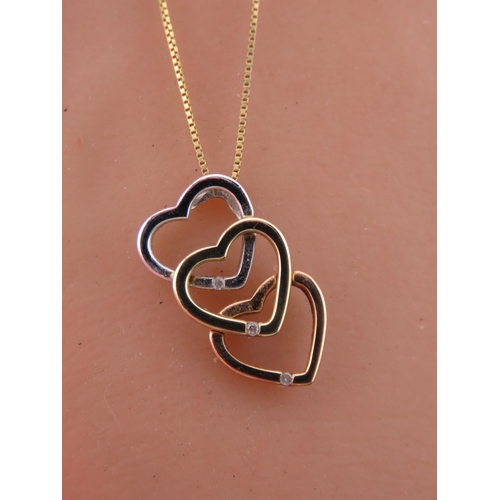 197 - A Brooks Bentley 9 carat tri colour gold heart pendant, formed as an interlocking three heart design... 