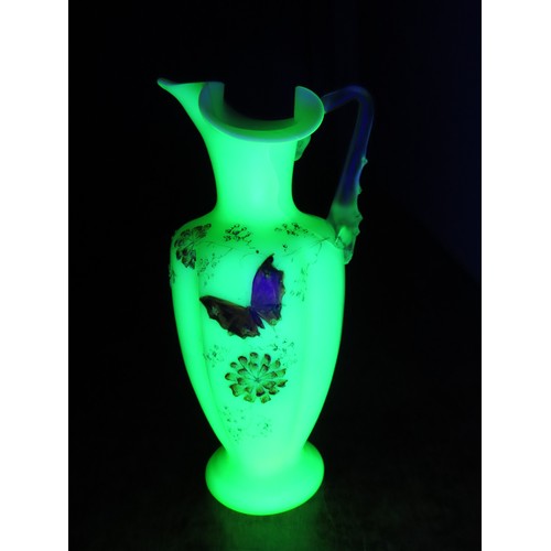 100 - A Victorian uranium glass jug, of baluster form with applied handle and butterfly and floral decorat... 