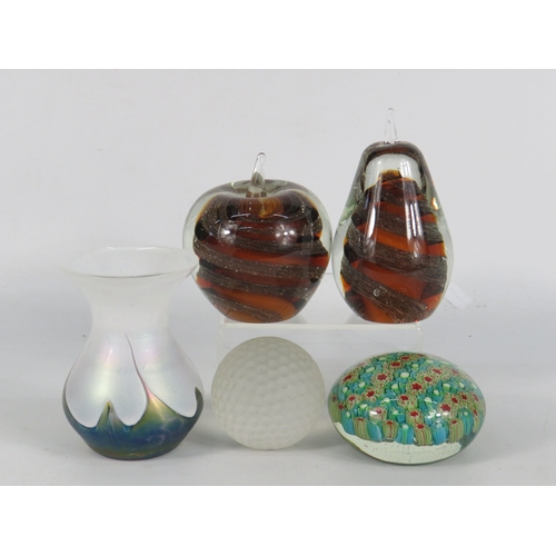 54 - Four glass paperweights and a small iridescent vase, including a Royal Doulton glass golf ball paper... 