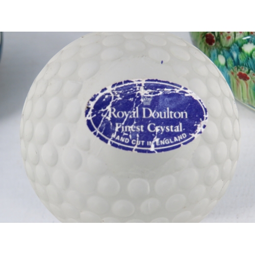 54 - Four glass paperweights and a small iridescent vase, including a Royal Doulton glass golf ball paper... 