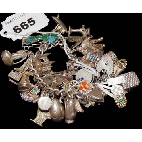 665 - A Very Heavy Charm Bracelet approx, 33 Charms